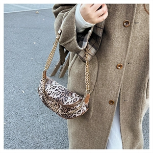 Close-up of leopard print half-moon bag with gold chain and brown leather trim detailing