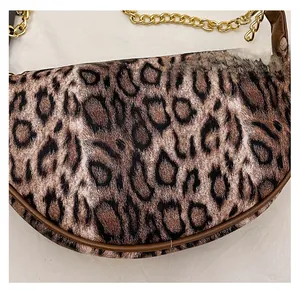 Detail shot of leopard print handbag featuring matte texture and gold chain strap