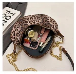 Macro view of leopard print crescent bag interior showing spacious storage for cosmetics