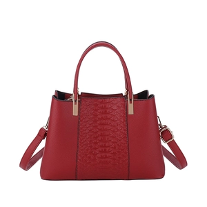 Red crocodile embossed tote bag with round handles and detachable shoulder strap in plain white background