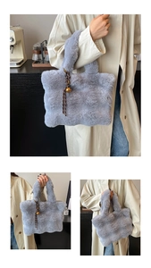 Detail of grey plush tote bag featuring soft faux fur texture and cute bell charm accessory