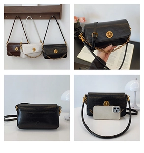 Detail of trendy crossbody bags with crocodile pattern, gold buckle and chain strap