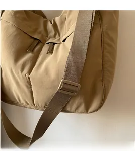 Détail de la bandoulière réglable et texture du sac à bandoulière en nylon kaki