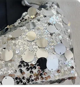 Macro shot of silver sequins on white mesh fabric of the stylish shoulder bag