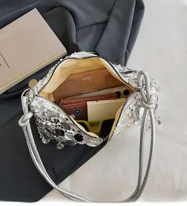 Detail of silver sequin shoulder bag showing spacious interior with daily essentials
