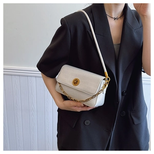 Detail of silver-grey textured handbag with gold chain and metal twist-lock buckle
