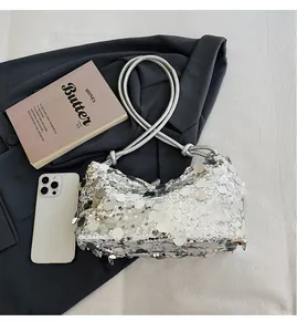Macro shot showing silver sequin texture and compact size of the metallic underarm bag