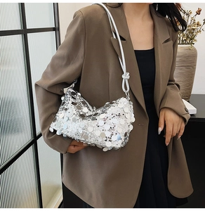 Detail of silver sequin shoulder bag with large metallic discs and knotted strap