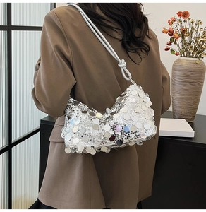 Detail of silver sequin shoulder bag showing metallic circular texture on brown blazer