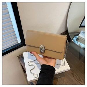 Detailed close-up of khaki mini box bag with silver metal twist lock and chain strap