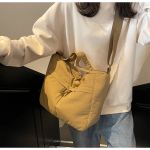Gros plan d'un grand sac cabas kaki en toile avec détails plissés et large bandoulière