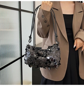 Detail of black sequin hobo bag with round paillettes and knotted shoulder strap