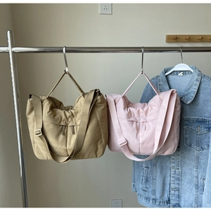 Détail de sacs bandoulière en nylon kaki et rose avec bandoulières réglables et texture plissée