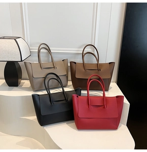 Set of four textured leather tote bags in black burgundy brown and beige on white stands