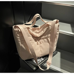 Détail du sac fourre-tout rose clair avec doubles poches zippées et texture en nylon