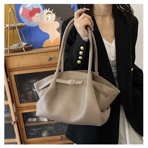 Close-up of litchi texture on khaki grey tote bag with decorative buckle and strap