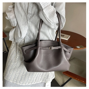 Detail of dark grey pleated leather tote bag with metal buckle and double handles