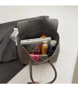 Top view showing large capacity interior of grey-brown faux leather tote bag with daily items