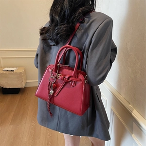 Red matte leather tote bag with heart charm and shoulder strap for women fashion