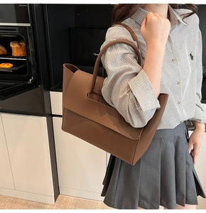 Brown lychee leather tote bag with unique flap design shown in a modern lifestyle setting