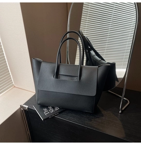 Detail of black lychee grain leather tote bag showing high-quality texture and handle
