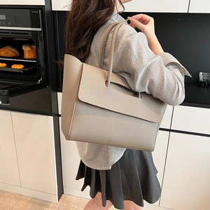 Detailed view of khaki pebbled leather tote bag with large capacity and flap closure