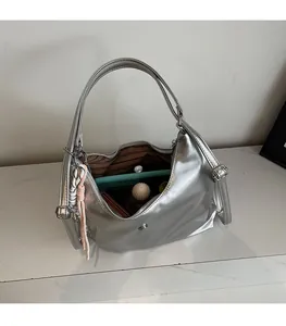 Vue intérieure du sac argenté métallisé montrant la grande capacité et la doublure rayée