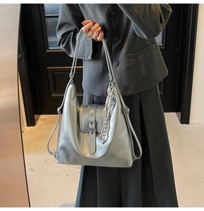 Détail du sac cabas argenté métallisé avec rabat à boucle et pendentif en cuir
