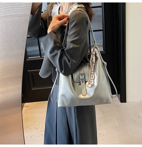 Détail du sac cabas argenté brillant avec boucle en métal et finition effet miroir chic