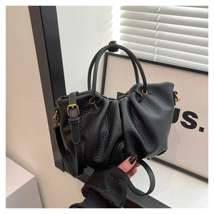 Gros plan du sac en cuir plissé noir avec des détails métalliques dorés élégants