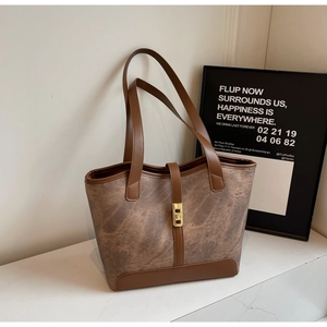 Détail d'un grand sac cabas marron avec texture marbrée et boucle rectangulaire dorée