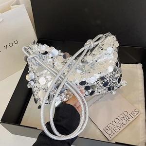 Silver sequin shoulder bag with leather knotted straps on a stylish product scene