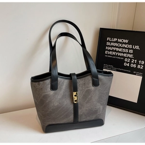 Détail du sac cabas en toile taupe avec finitions en cuir noir et boucle dorée chic