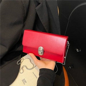 Minimalist red rectangular chain bag with silver twist lock and sleek metal strap