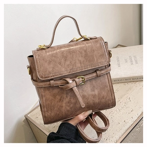 Close-up of vintage brown leather backpack with textured finish and gold metal hardware