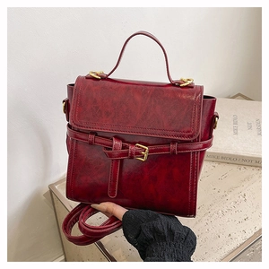Close-up of vintage burgundy leather handbag with top handle and adjustable strap