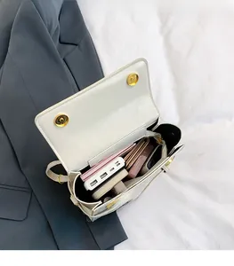 Detail view of cream crossbody bag interior showing spacious storage and magnetic rings