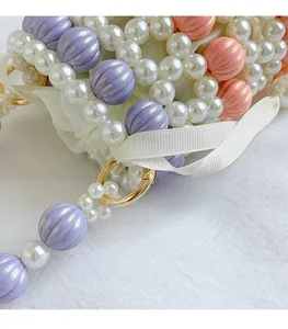 Détail macro de perles tissées à la main avec boucle dorée et accents de ruban de soie