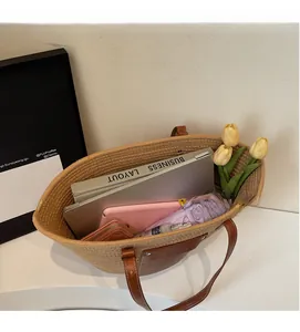 Detail of summer straw tote bag showing spacious interior with laptop and accessories