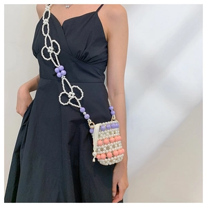Détail du sac bandoulière en perles tissées main avec motifs floraux sur robe noire