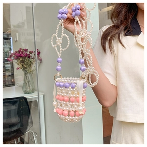 Détail du sac seau perlé à la main avec perles pastel et fermeture à cordon en soie
