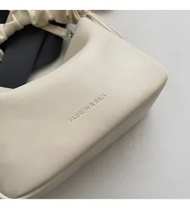 Detail of beige leather texture with FASHION & BAGS embossing and ruffled handle