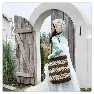 Détail du sac cabas en paille tissé à la main et du bonnet en tricot assorti