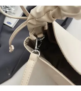 Detail of silver metal buckle and brown lining on a cream soft leather handbag