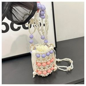 Détail du sac seau fait main avec perles blanches et motifs tissés violets