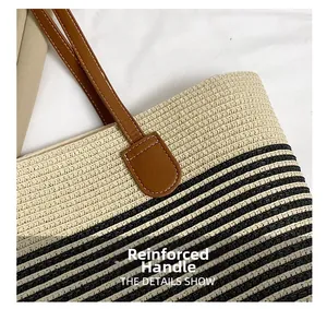Close-up of reinforced brown leather handle and striped straw tote bag stitching