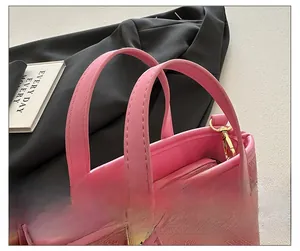 Detail of pink bucket bag featuring woven fabric textures and gold metal hardware hooks