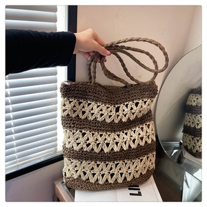 Détail macro du tissage crocheté floral marron et beige sur le sac fourre-tout en paille
