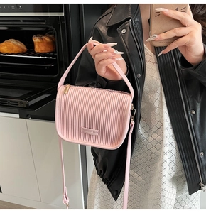 Detail of pink pleated texture bucket bag with Fashion & Bags logo and adjustable strap