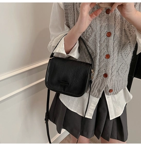 Detailed view of the black pleated faux leather bucket bag with a stylish vertical texture